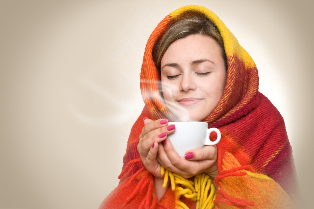 Простудившиеся девушка пьет чай 